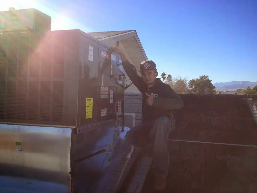 HVAC technician performing AC Tune-Up on a rooftop unit in Ambler